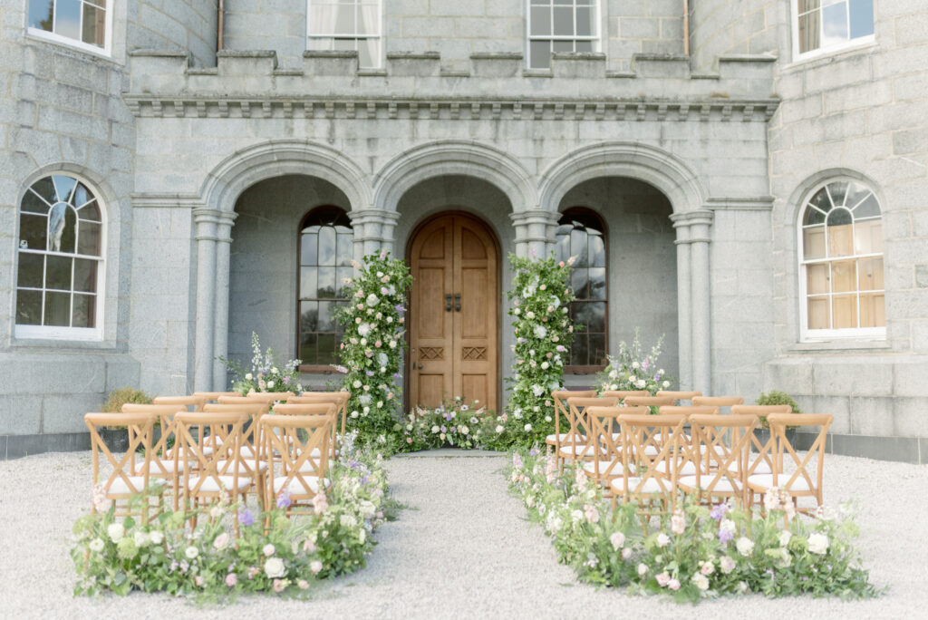 Luxury castle wedding venue Scotland, Cluny Castle, outdoor ceremony design with abundant floral meadows and broken arch.