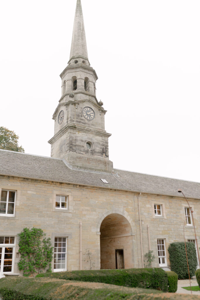 The elegant clock tower and entrance to Penicuik House, Penicuik Estate, Scotland — a private country estate wedding venue near Edinburgh. Image by renowned wedding photographer Scotland, Jill Cherry Porter, in connection with Scottish destination wedding planner, Emma Matthews founder of Timeless White Wedding Planning, and Jill Alexander, abundant wedding floral designer UK, The Little Flower Atelier.