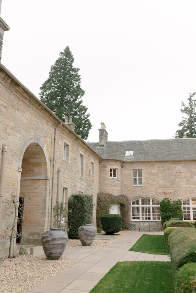 The beautiful courtyard grounds of Penicuik House, Penicuik Estate, Scotland — a private country estate wedding venue near Edinburgh. Image by renowned wedding photographer Scotland, Jill Cherry Porter, in connection with Scottish destination wedding planner, Emma Matthews founder of Timeless White Wedding Planning, and Jill Alexander, abundant wedding floral designer UK, The Little Flower Atelier.