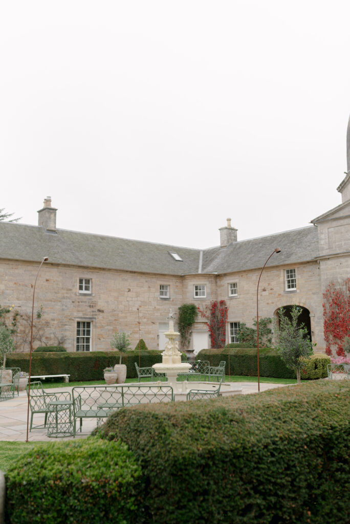 The stunning central fountain of the Penicuik House courtyard — an exclusive use, country estate wedding venue, Scotland. Image by luxury wedding photographer Scotland, Jill Cherry Porter, in connection with one of the best wedding planners in Scotland, Emma Matthews, founder of Timeless White Wedding Planning, and Jill Alexander, abundant wedding florist UK, The Little Flower Atelier.