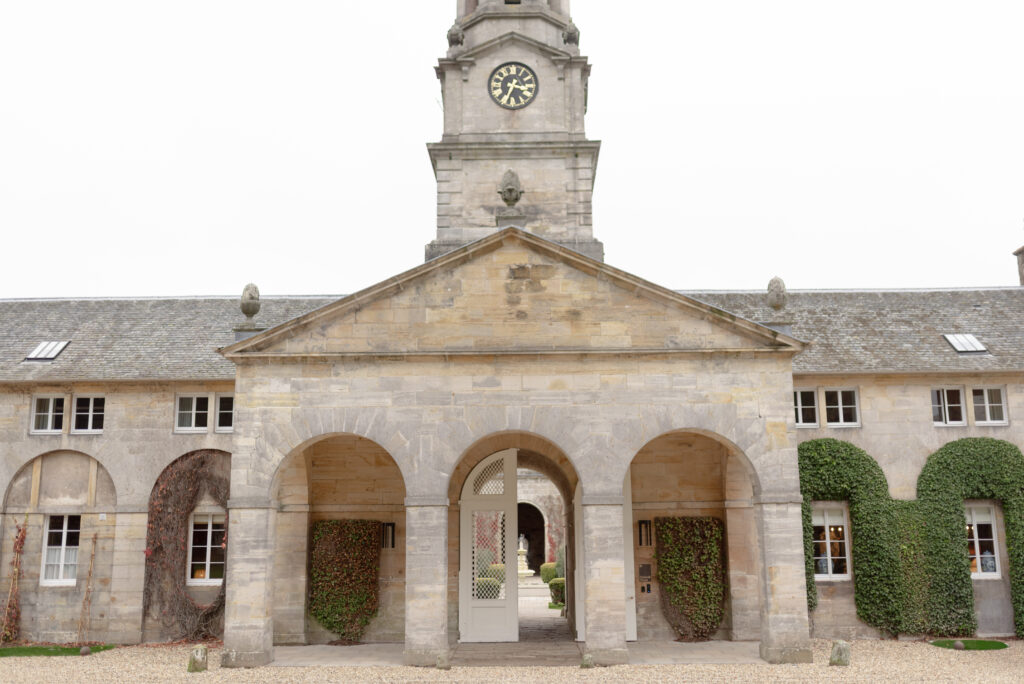 Penicuik House main entrance with elegant fountain, evergreen gardens and the storied, historic backdrop of Penicuik Estate, near Edinburgh Scotland. Image by award winning fine art wedding photographer, Jill Cherry Porter. Top UK Wedding photographer featured in Vogue and Vanity Fair.