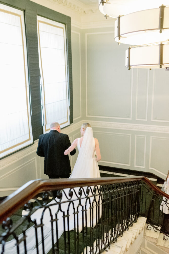 Fine art wedding photography of a Bride and her Father on the grand staircase of Gleneagles Hotel, Scotland, as they approach the wedding ceremony. Image by luxury Gleneagles wedding photographer, Jill Cherry Porter.