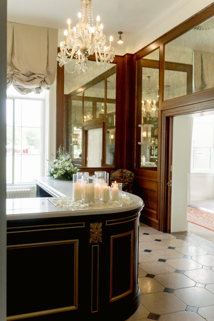 Gleneagles wedding interior bar area with chandelier and hurricane candles with petals. Image by Gleneagles recommended wedding photographer, Jill Cherry Porter.