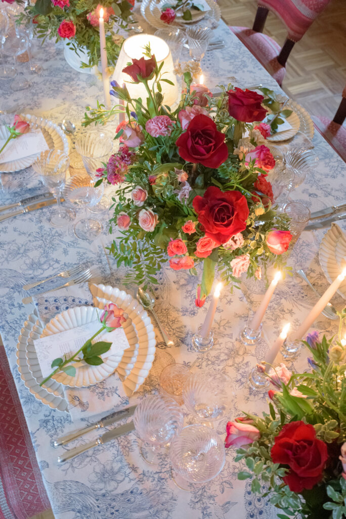 Elegant wedding tablescape with romantic floral centrepiece, layered tableware and candlelight at Penicuik House