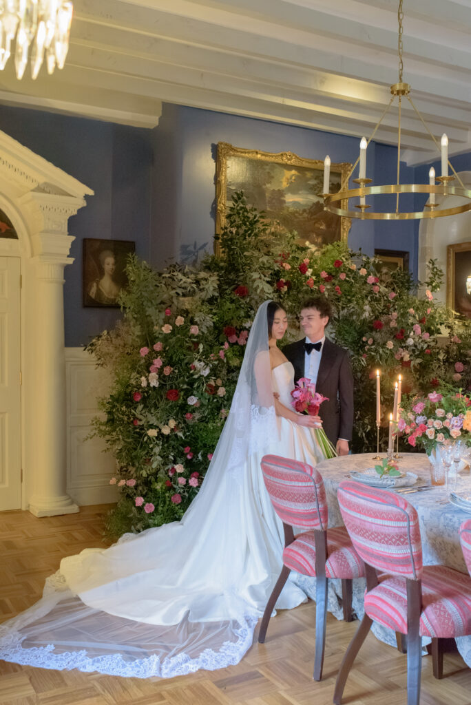 Bridal portrait of Bride and Groom by flower installation in Penicuik Estate Scotland, featuring Chatsworth Linens by Chateau Noir Event Hire.  Wedding Photography by Jill Cherry Porter.