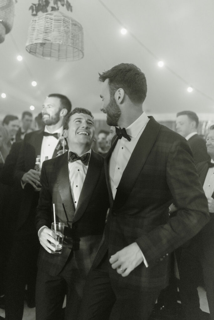 Grooms enjoy wedding reception in a sailcloth marquee on Penicuik Estate, Scotland destination wedding venue. Image by Penicuik House recommended wedding photographer, Jill Cherry Porter.