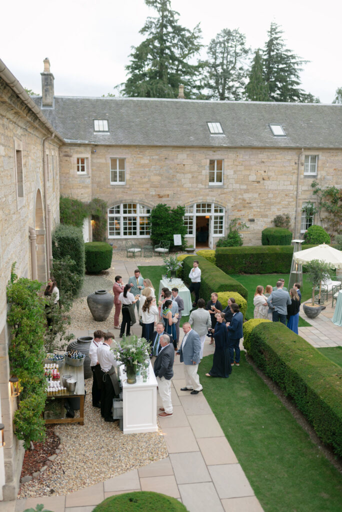 Penicuik House courtyard welcome party at Penicuik Estate, Scotland destination wedding venue. Image by Penicuik House recommended wedding photographer, Jill Cherry Porter.