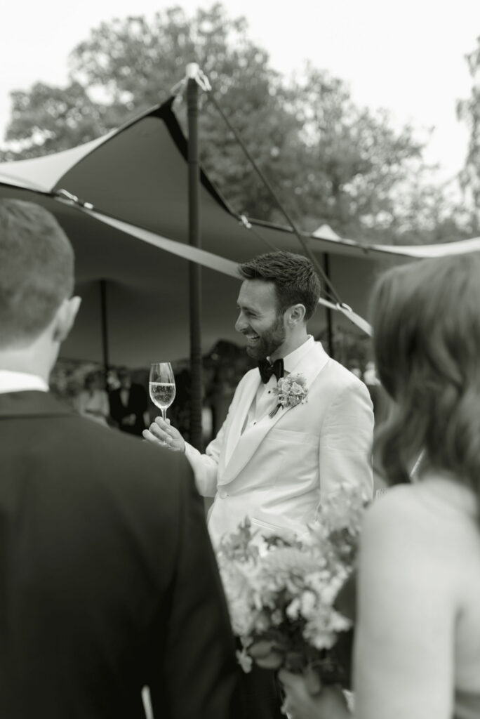 Groom enjoys cocktail hour by High Pond on Penicuik Estate, Scotland destination wedding venue. Image by Penicuik House recommended wedding photographer, Jill Cherry Porter.