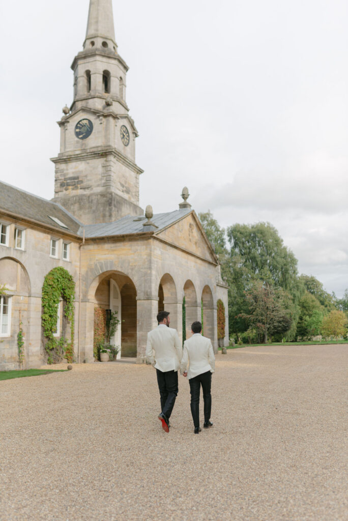 Couple walk through the grounds of Penicuik Estate, Scotland destination wedding venue, on their wedding day. Image by Penicuik House recommended wedding photographer, Jill Cherry Porter.